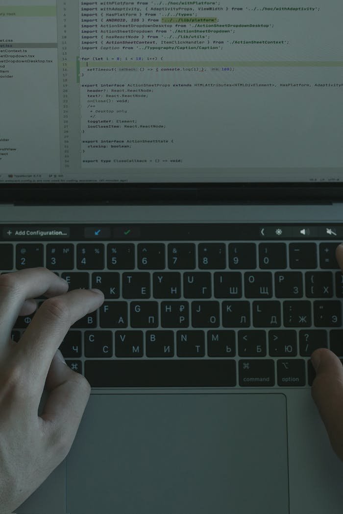why-choose-us Hands typing on a laptop with a visible coding interface, showcasing technology use.